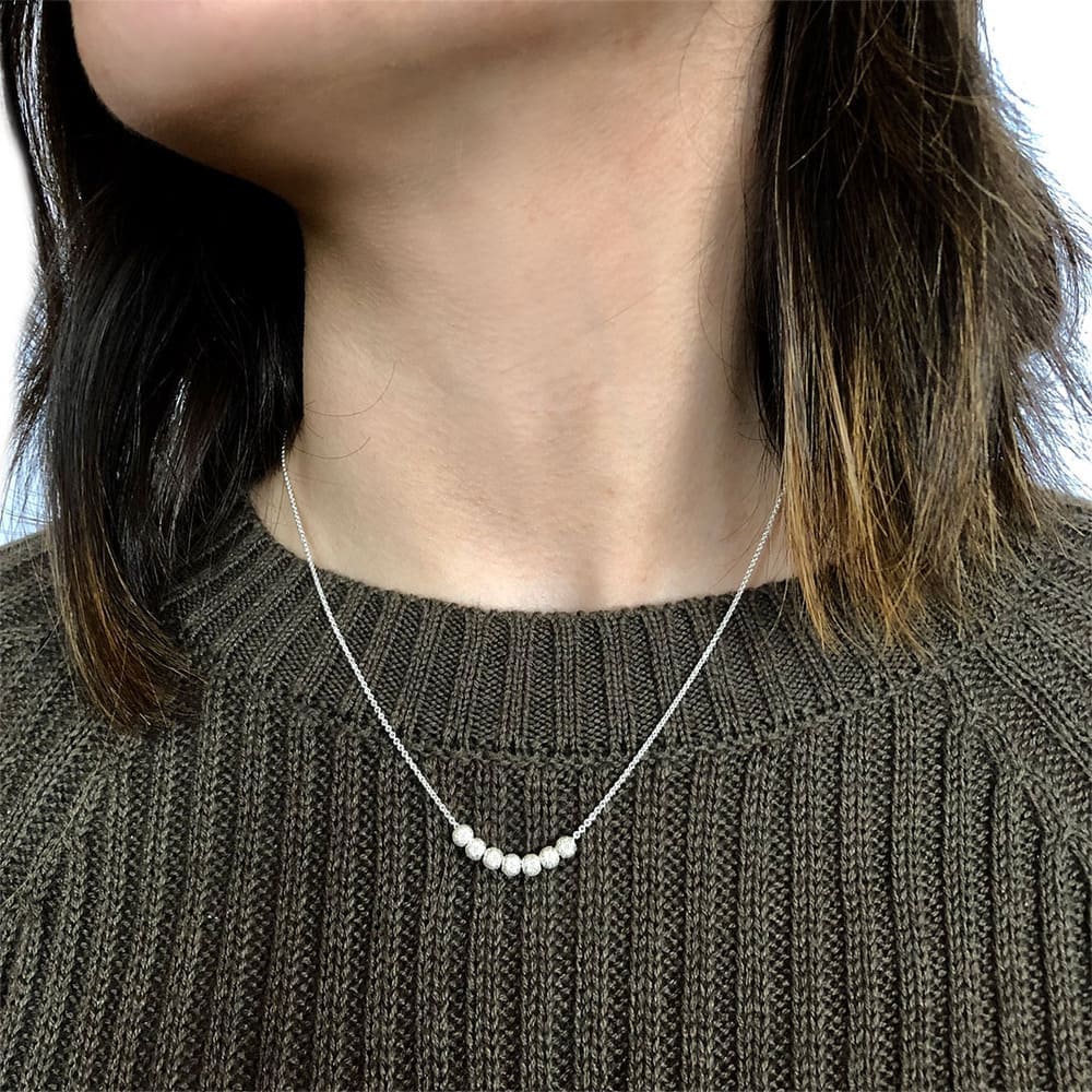 Delicate-balls-silver-necklace-with-model-Nueve-Sterling